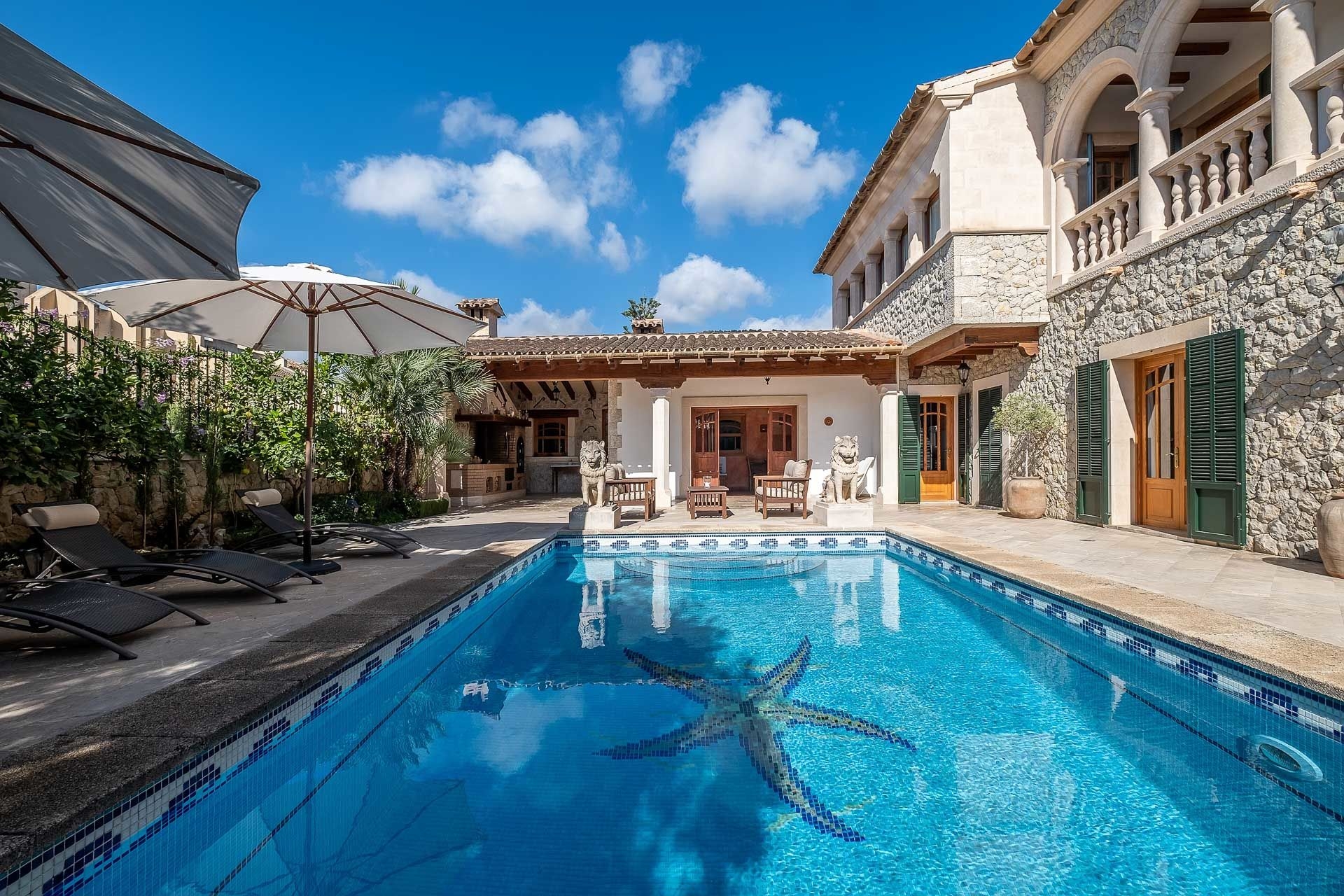Poolbereich und Terrasse mit Außenküche im Hintergrund