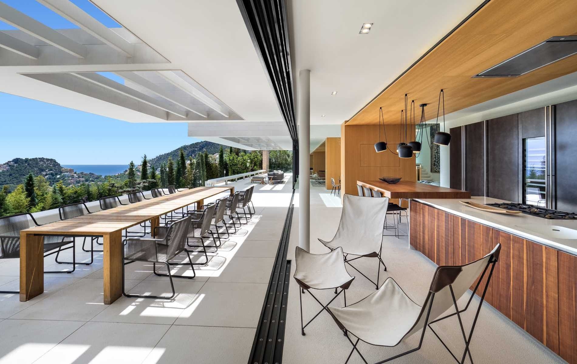 Küche und Terrasse bei geöffneten Panoramafenstern