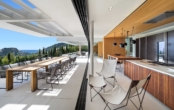 Küche und Terrasse bei geöffneten Panoramafenstern